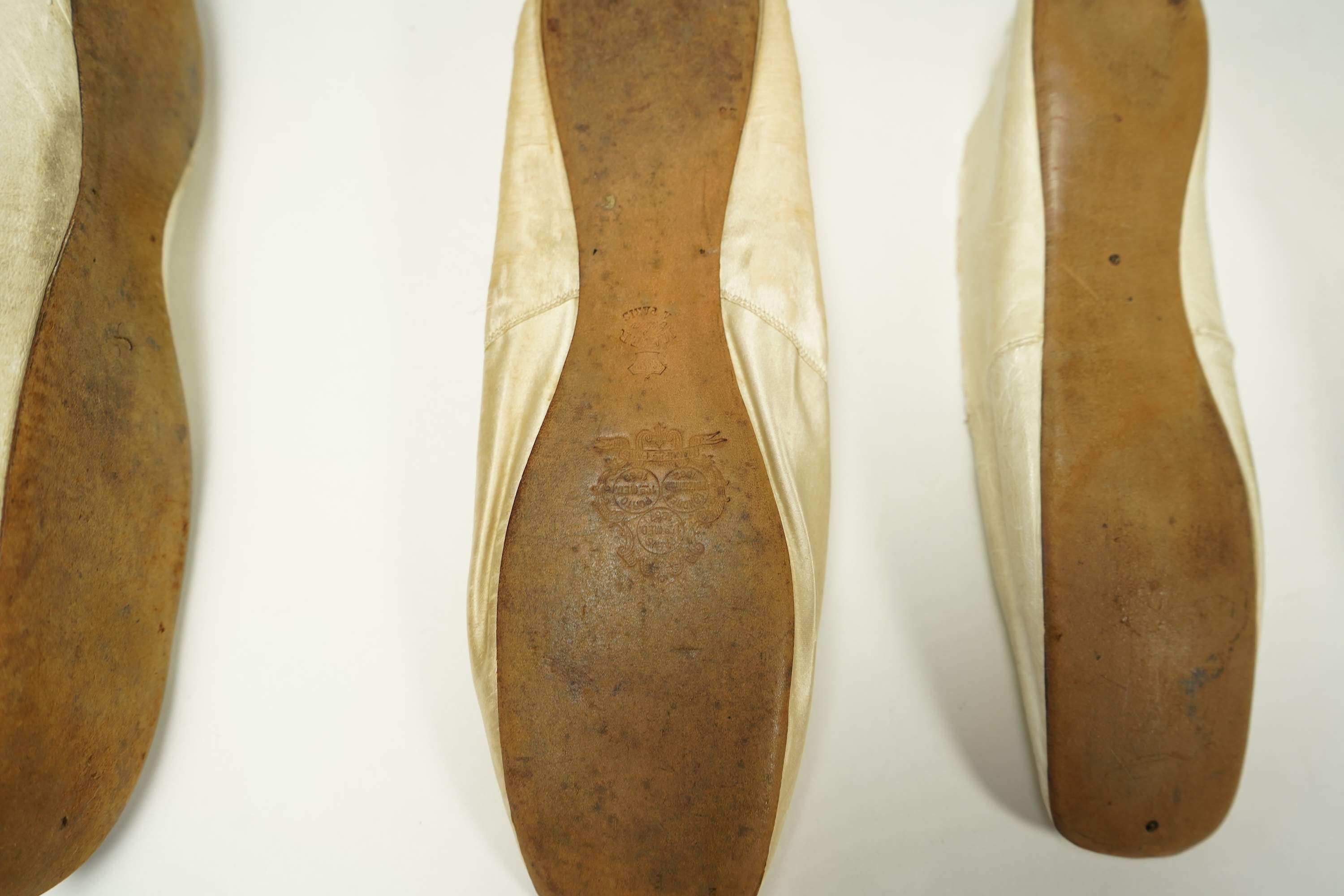 A 19th century hand made cream kid leather ladies ankle boot and four differing cream silk and satin single wedding shoes. All with leather soles. Possibly a traveller's sample range. Boots 24.5cm long (heel to toe). Con